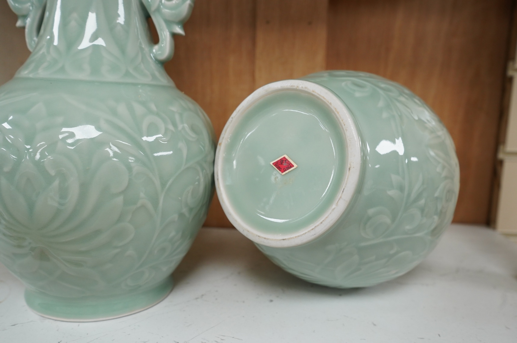 A pair of Chinese celadon glazed vases, decorated in low relief, 32cm high